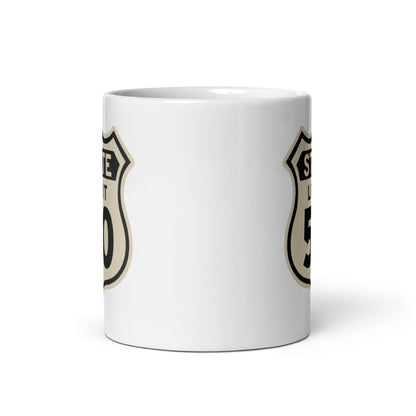 View of white ceramic mug with road sign graphic by State Limit Apparel to both sides.